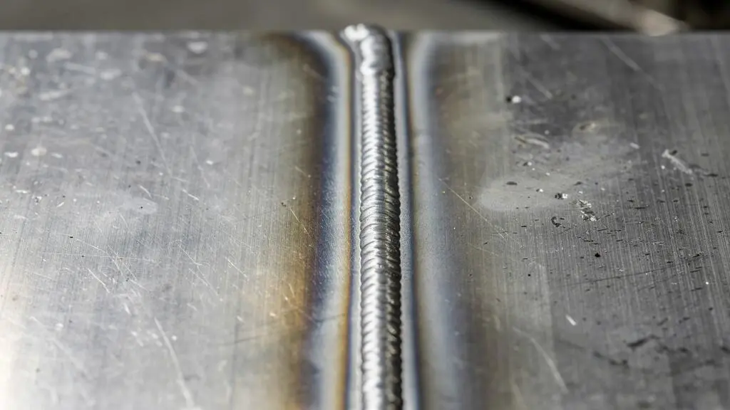 Gros plan sur un cordon de soudure laser montrant la zone thermiquement affectée minimale sur de l'acier inoxydable